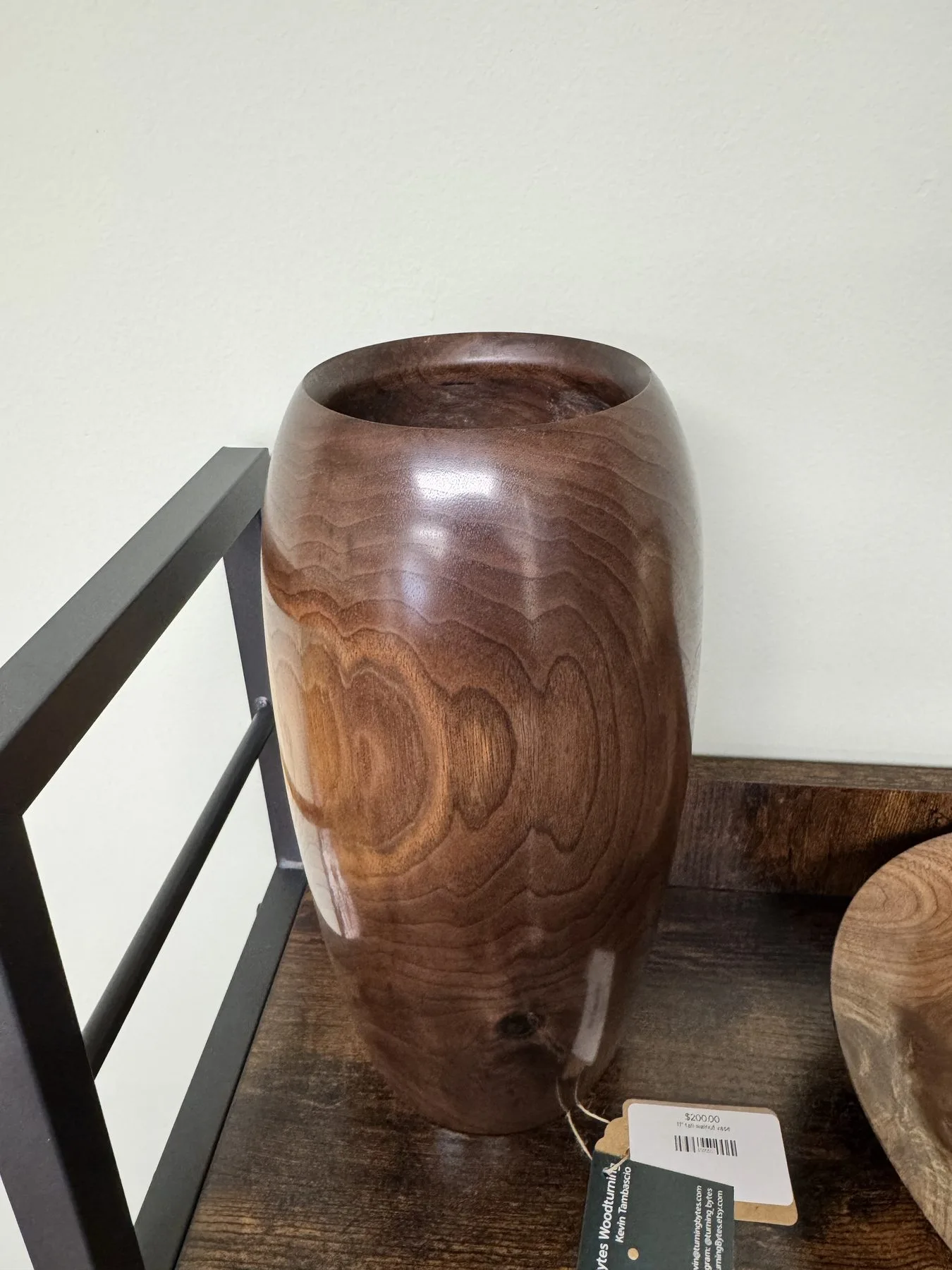 Angled top view of the walnut vase showing its small circular opening and rounded rim