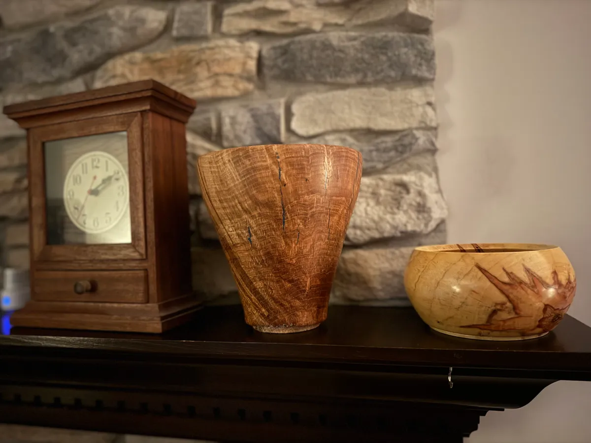 Detail view of white oak burl vase surface with glossy Waterlox finish, blue resin, and rippled figure