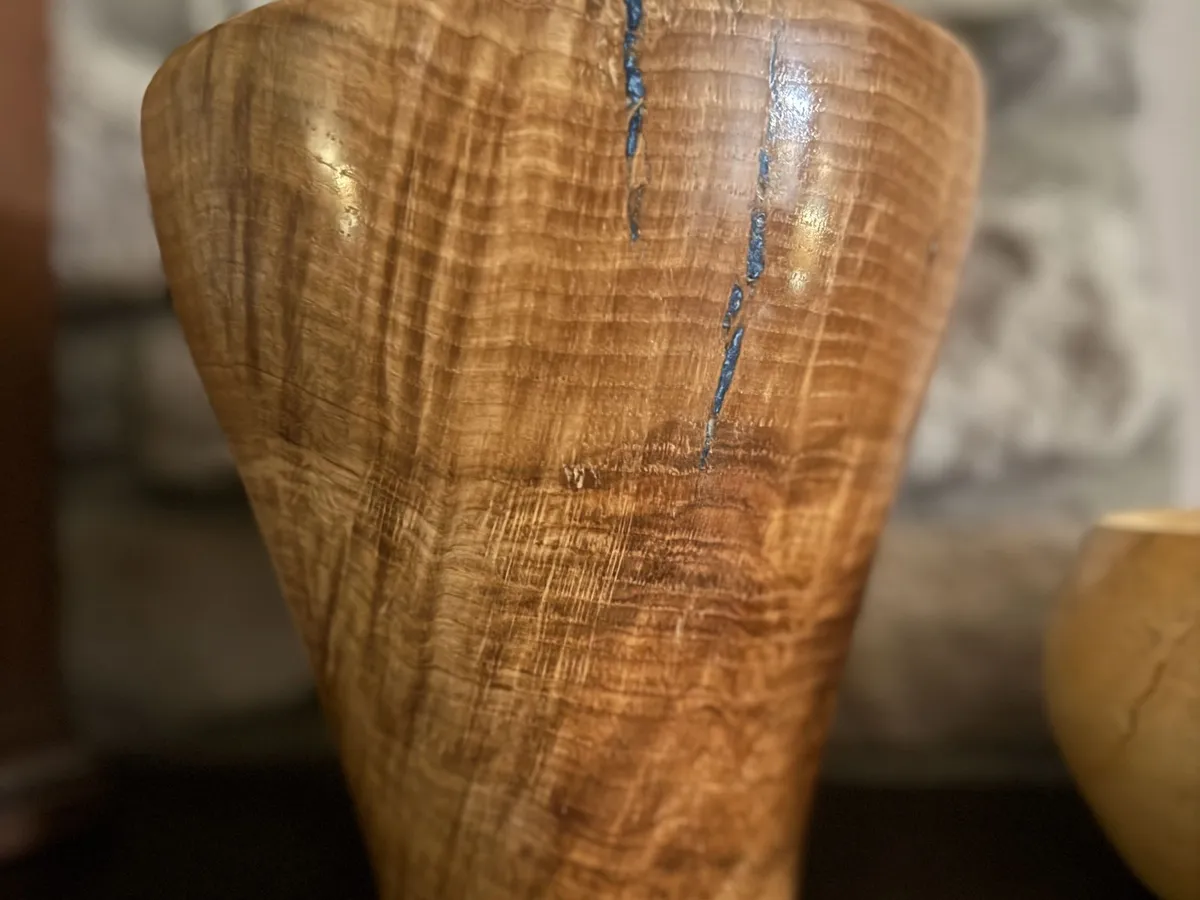 White oak burl vase with flared rim, Waterlox finish, and narrow blue resin crack fill near the rim