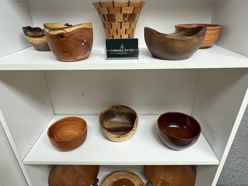 Turning Bytes display shelf showing a range of hand-turned bowls in cherry, walnut, maple, and ash