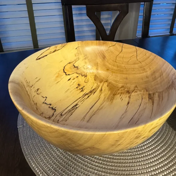 Close-up detail of spalted maple bowl showing dramatic black zone lines and fungal figure in pale wood