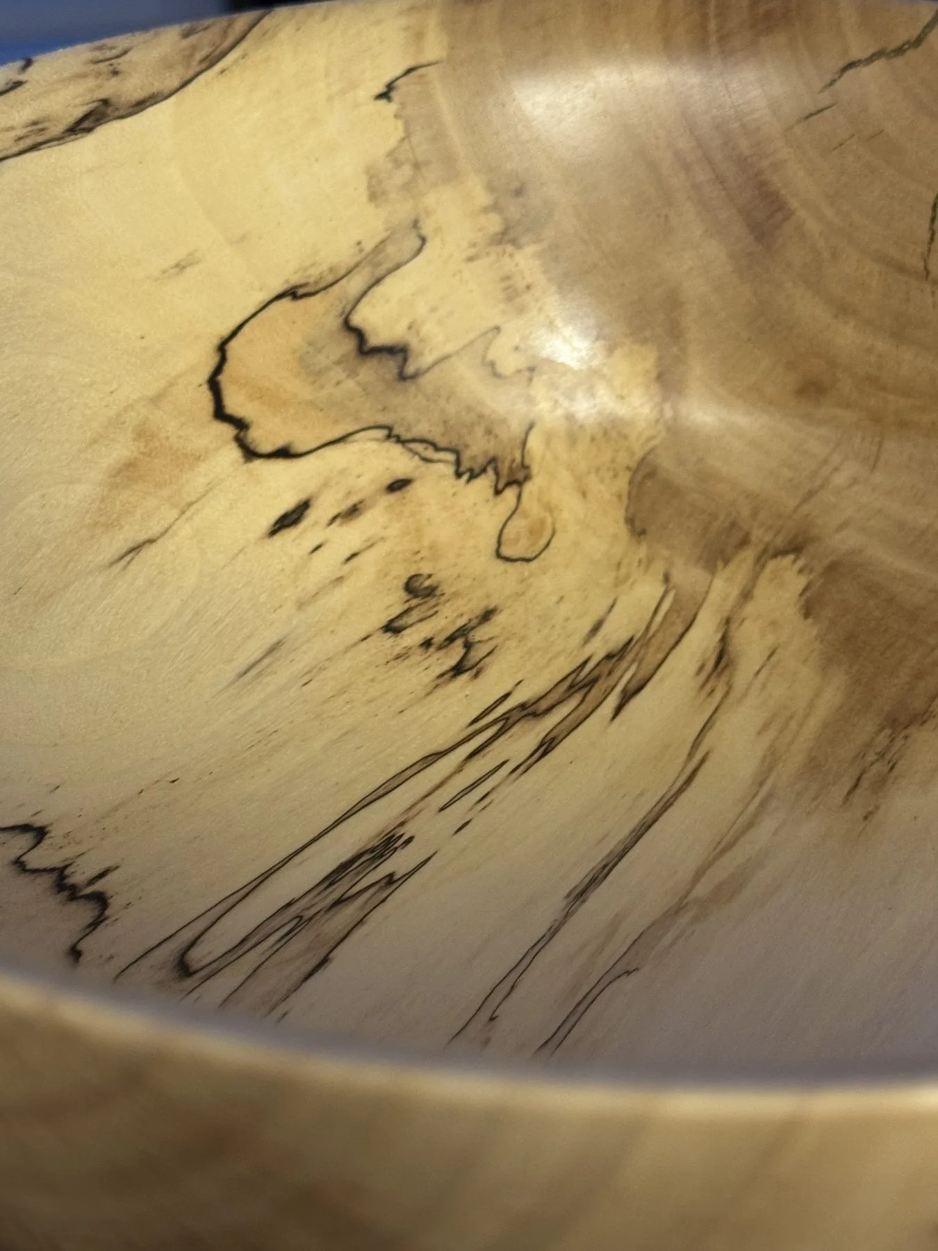 Close-up detail of spalted maple bowl showing dramatic black zone lines and fungal figure in pale wood