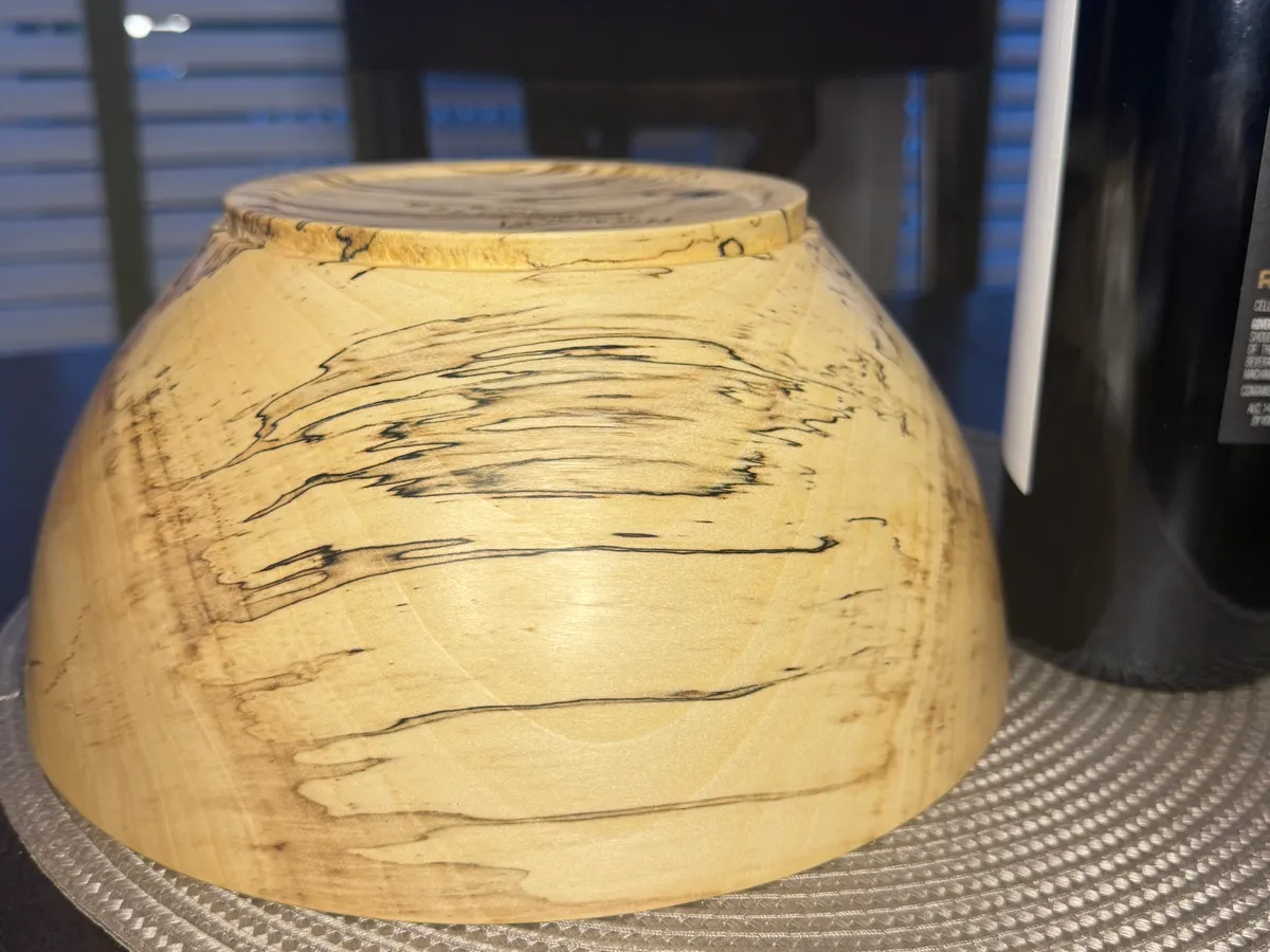 Close-up detail of spalted maple bowl showing dramatic black zone lines and fungal figure in pale wood