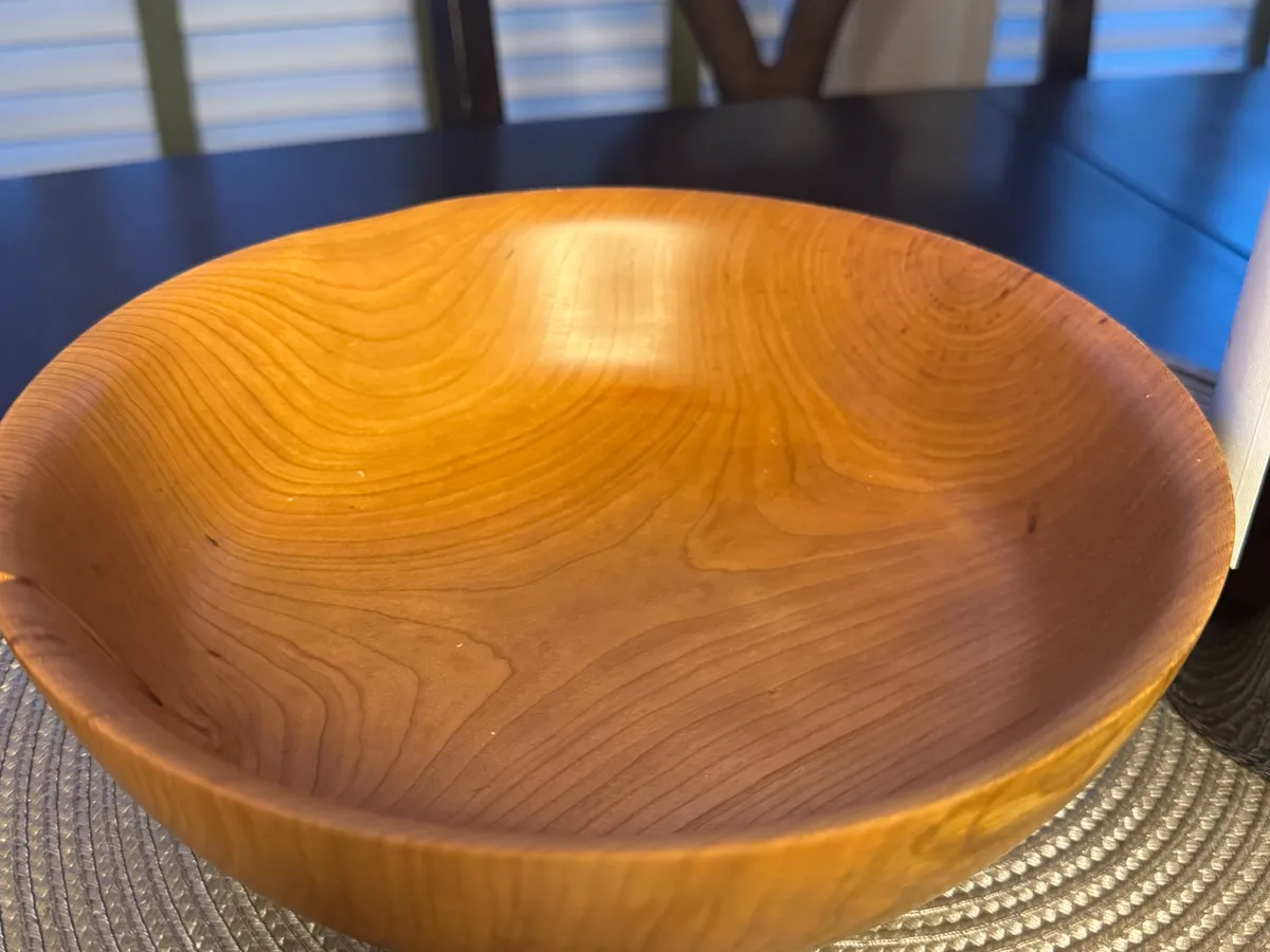 Cherry wood bowl with honey-amber grain and an open dining-table form