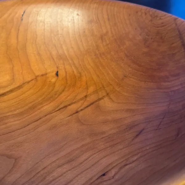 Close-up of cherry wood bowl interior showing rich amber grain and flowing growth rings