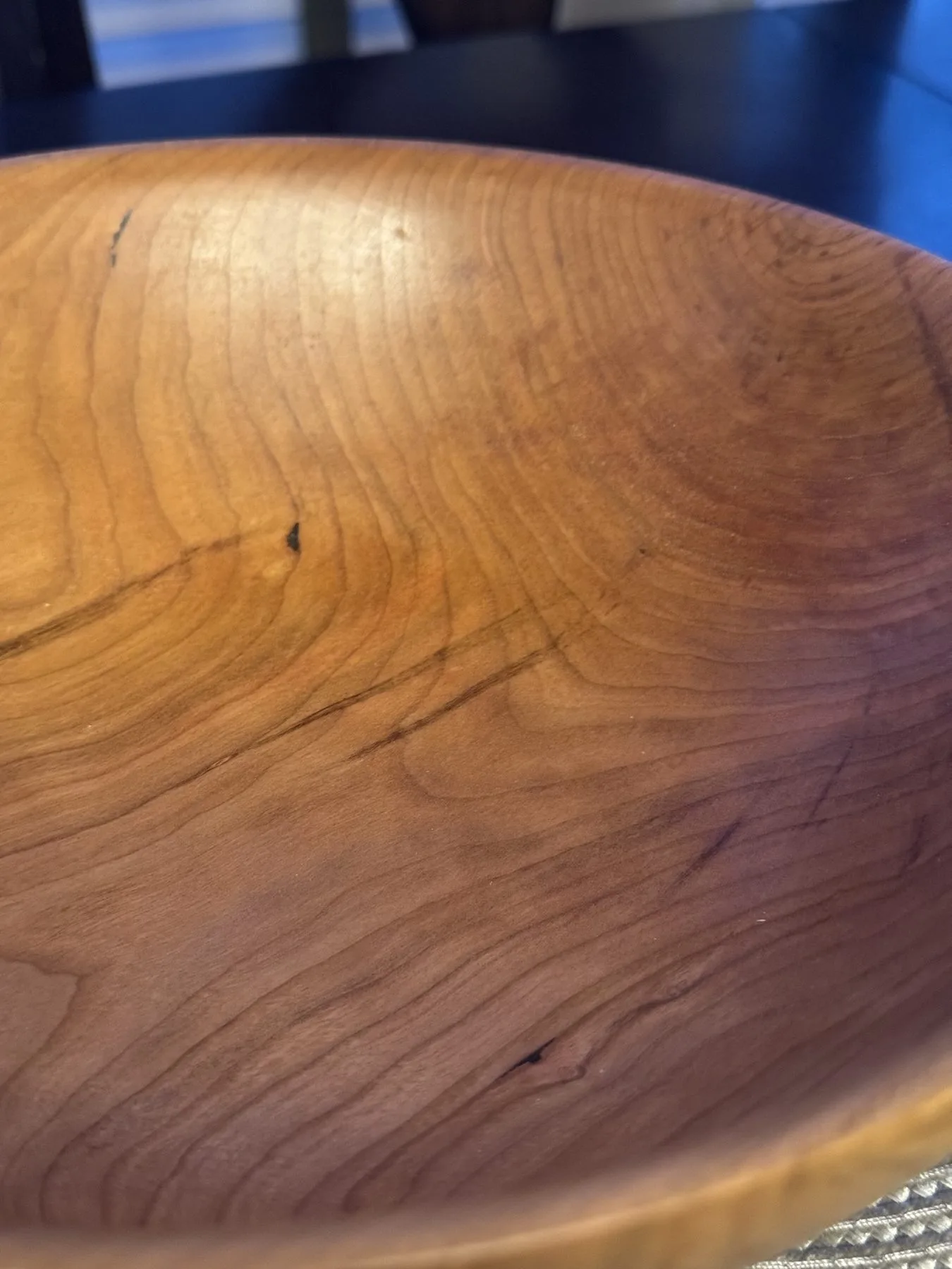 Close-up of cherry wood bowl interior showing rich amber grain and flowing growth rings