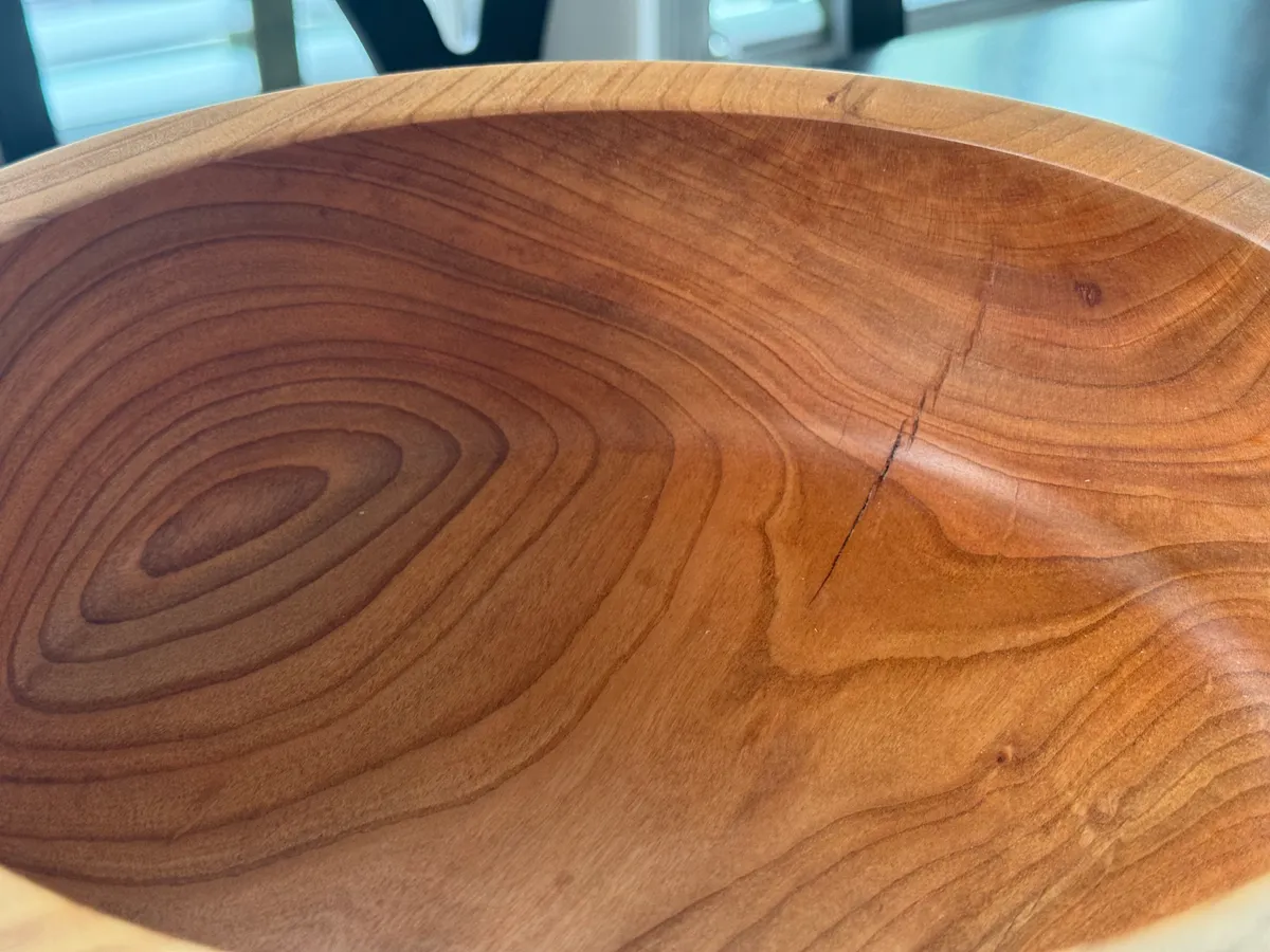 Interior of cherry wood bowl showing concentric grain rings and warm amber tone