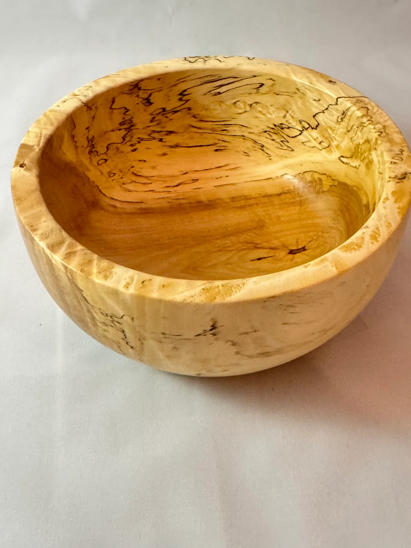 Small spalted maple bowl with dark zone lines and a compact rounded form