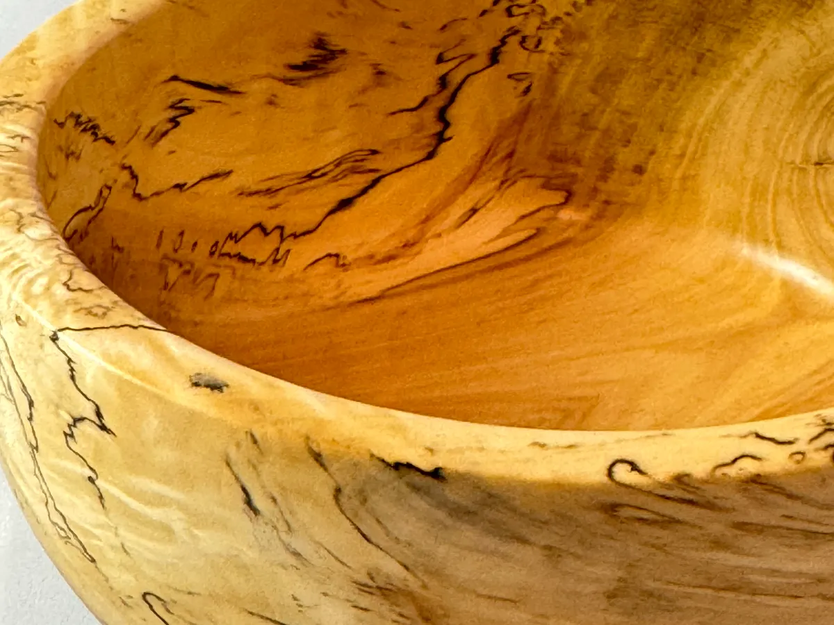 Side view of a smaller spalted maple bowl showing pale maple and black fungal figure
