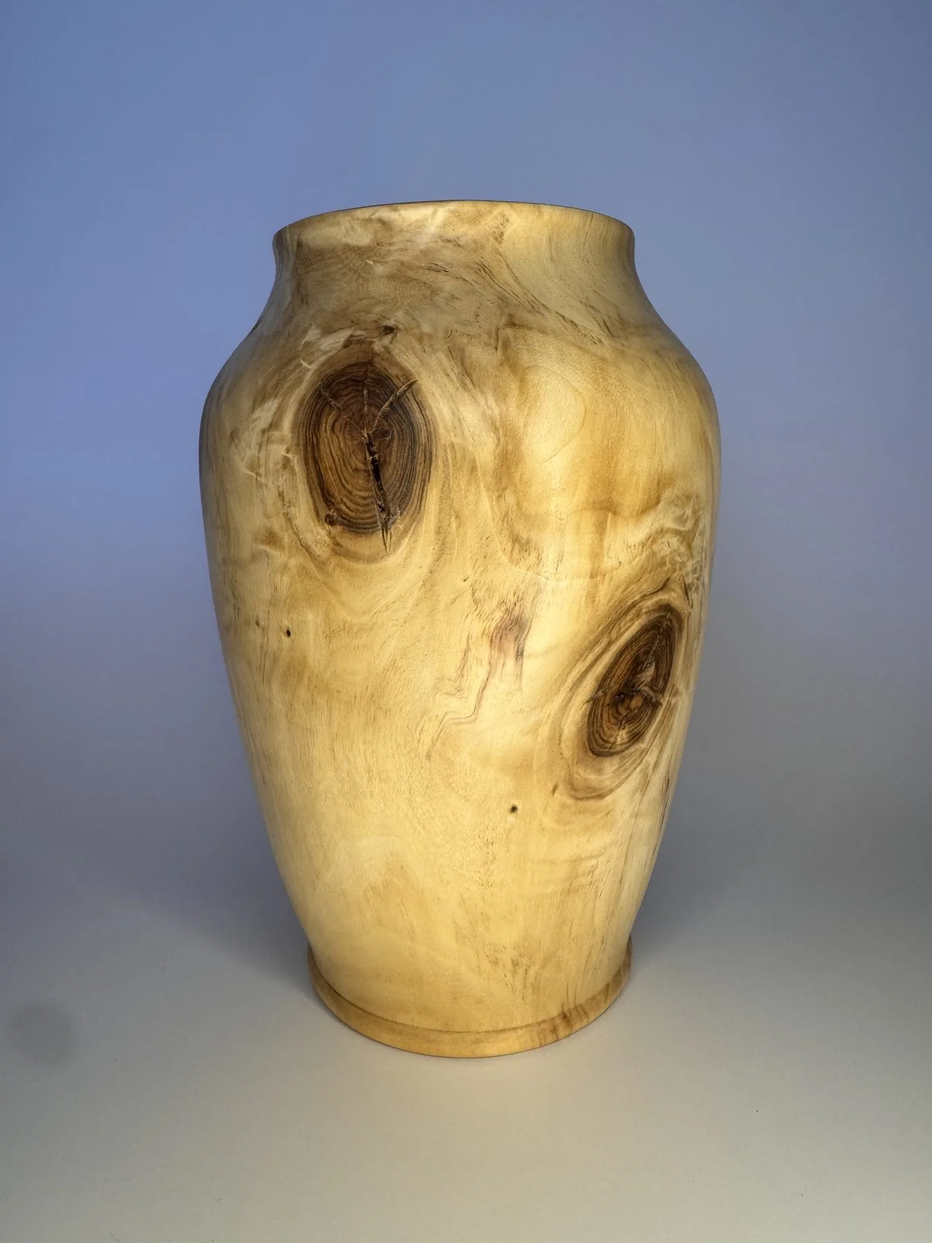Maple vase showing multiple dark knot eyes and warm tung oil finish