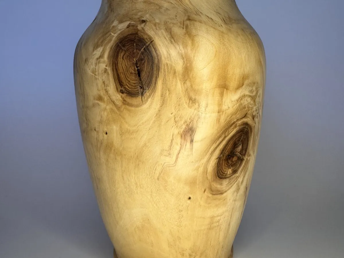 Maple vase showing multiple dark knot eyes and warm tung oil finish
