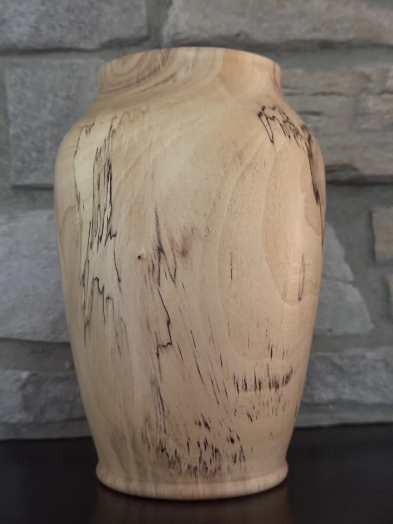 Back view of maple vase showing dark spalted streaks running down the pale wood