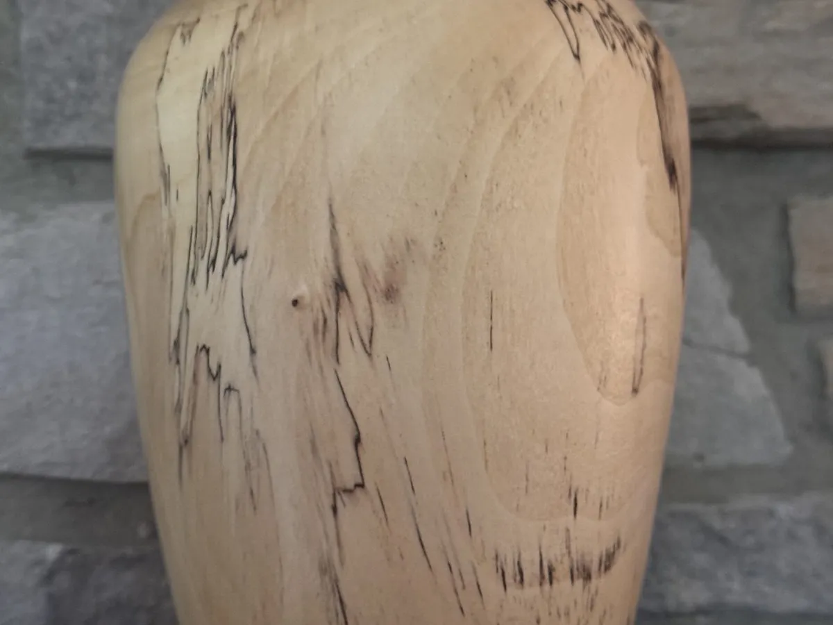 Back view of maple vase showing dark spalted streaks running down the pale wood