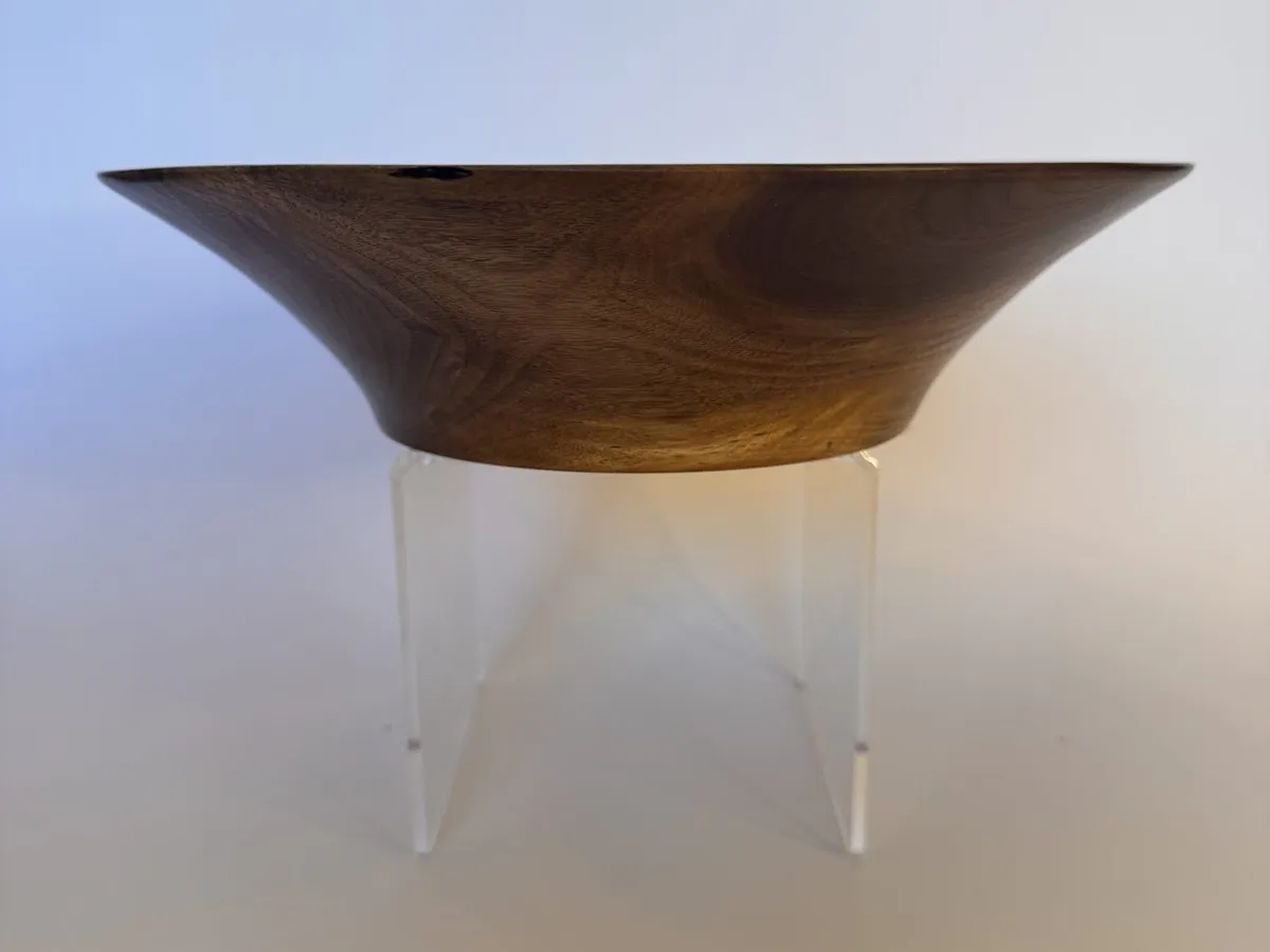 Side profile of low flared walnut bowl with thin rim and small foot