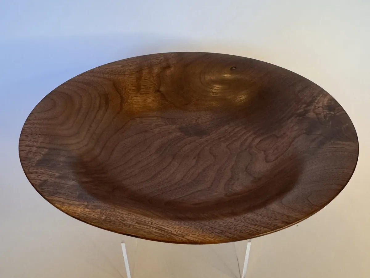 Shallow flared walnut bowl showing wide open rim and dark swirling interior grain
