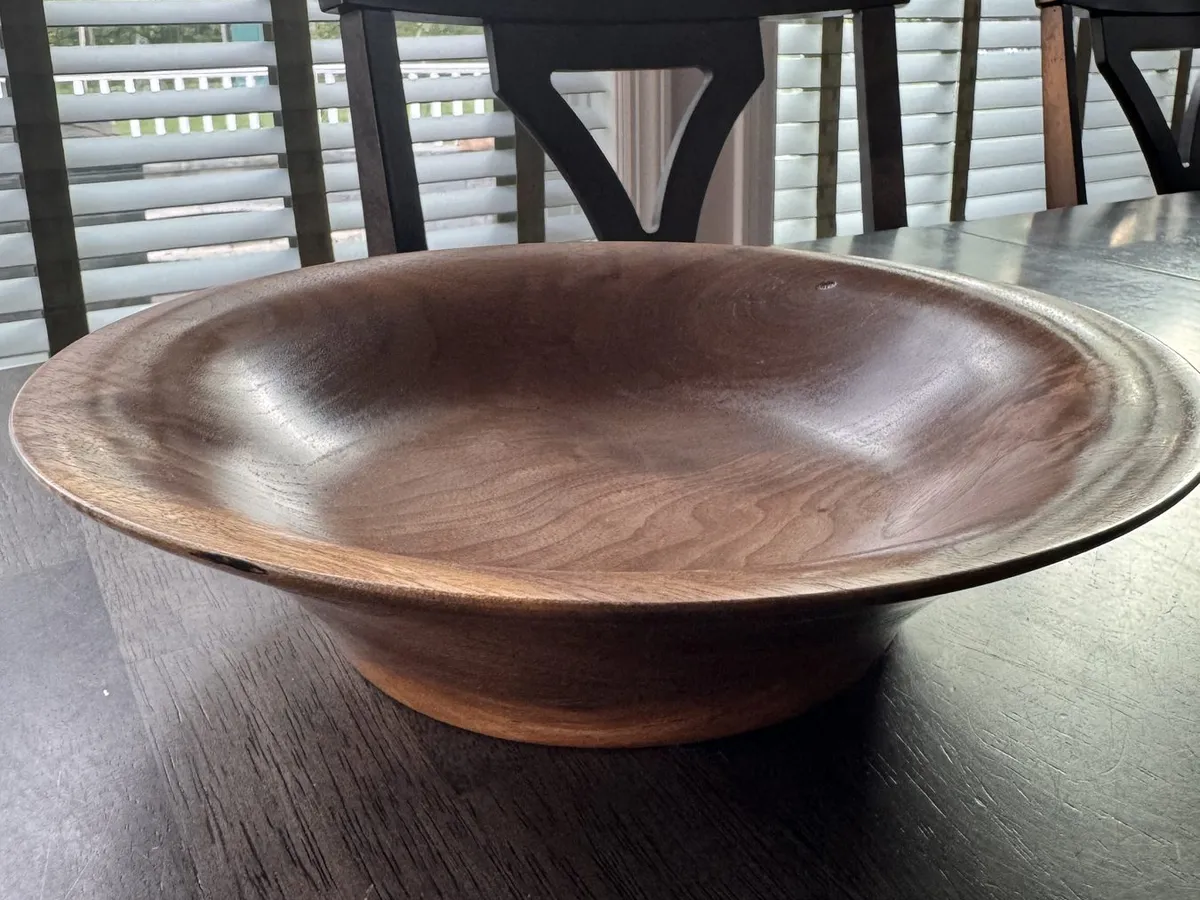 Flared walnut bowl displayed on a table in natural light