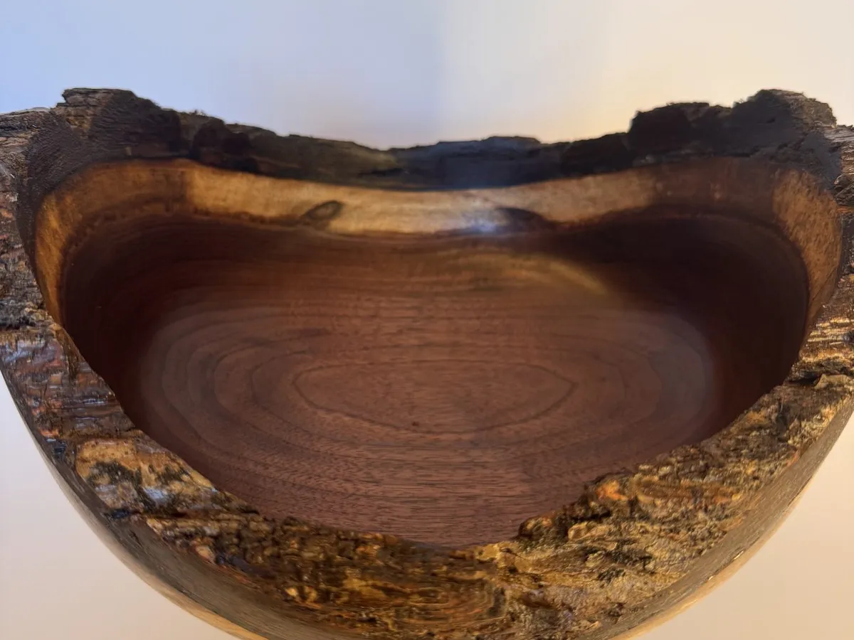 Deep natural edge walnut bowl with intact bark rim and warm interior