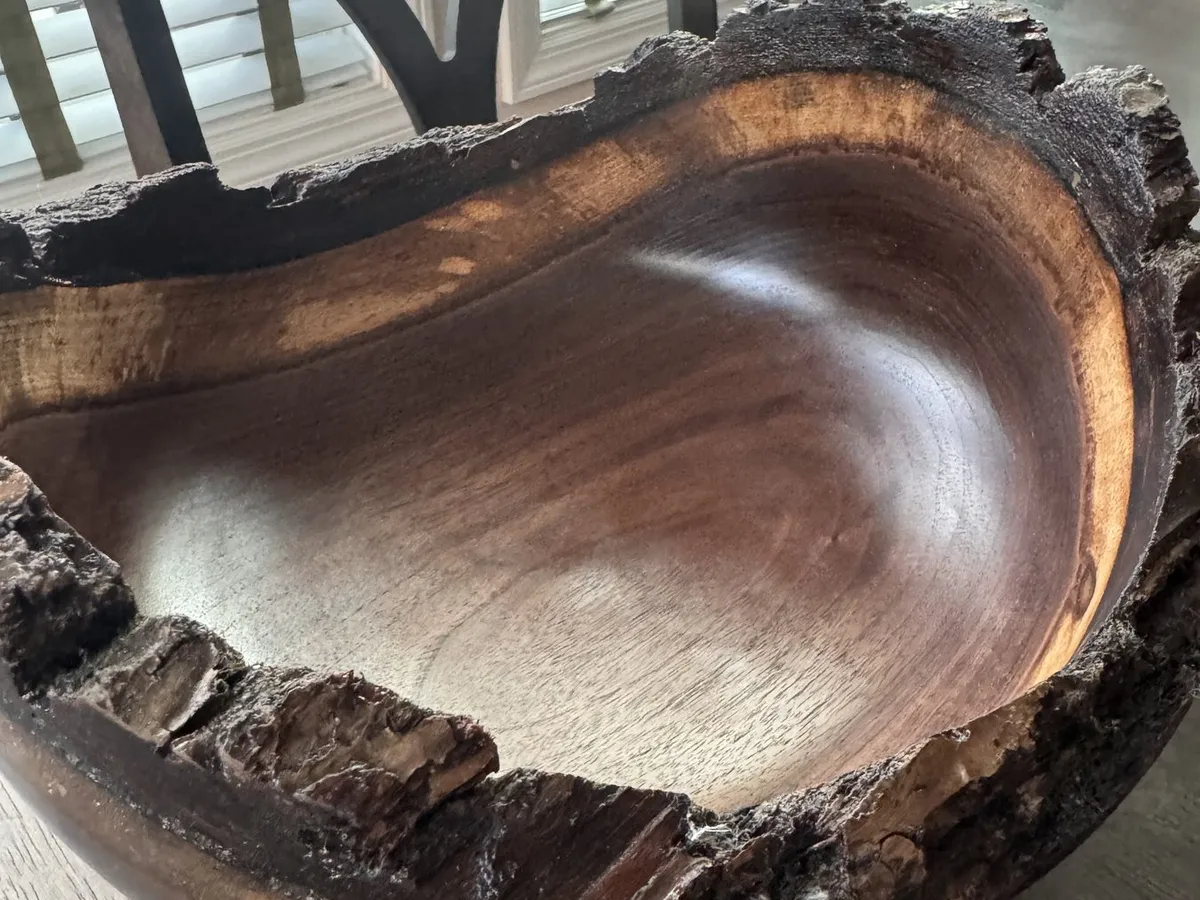 Angled tabletop view of deep walnut bowl with intact bark around the rim
