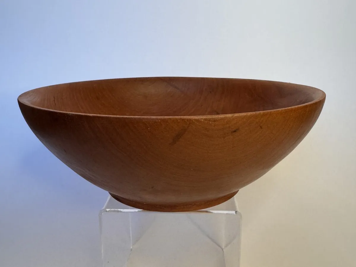 Side profile of simple hand-turned cherry bowl with small raised foot