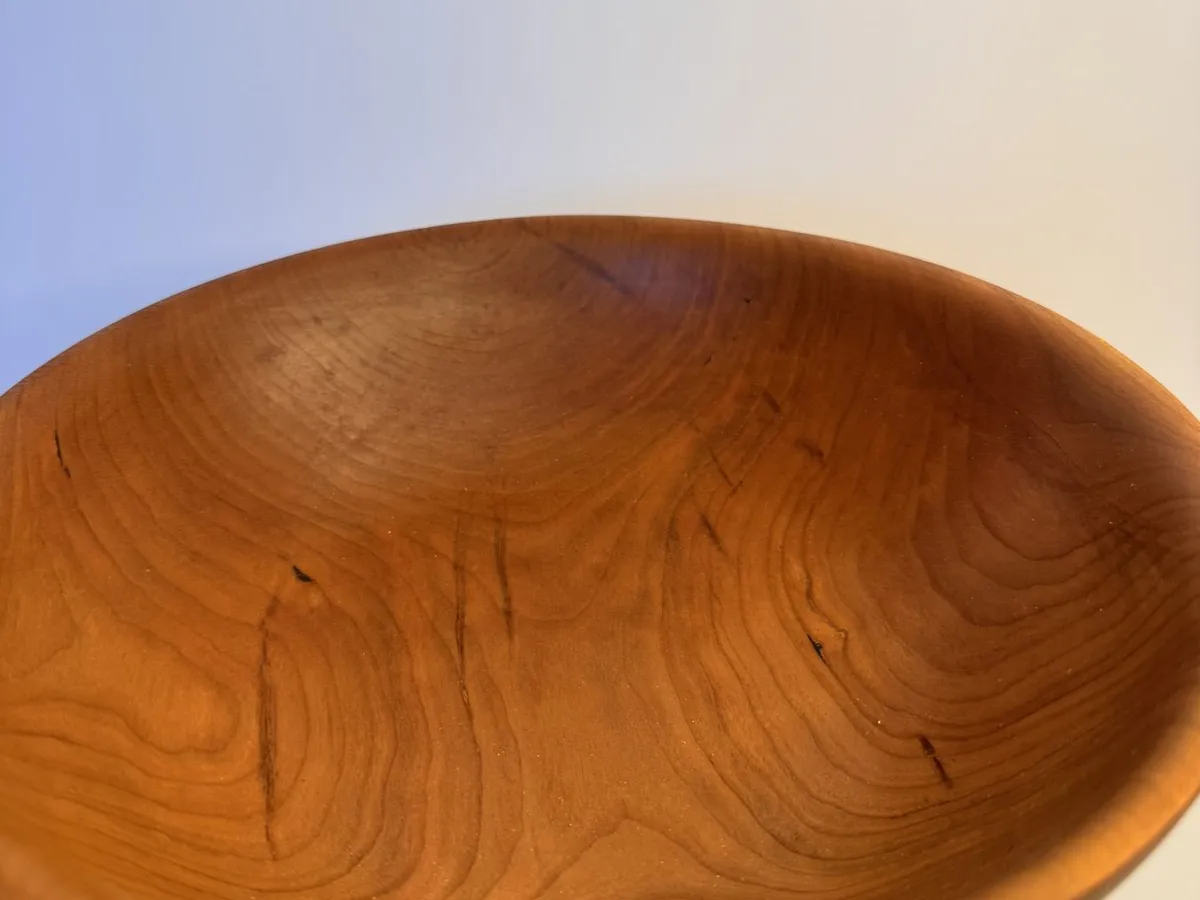 Interior view of cherry bowl showing warm grain and rounded rim