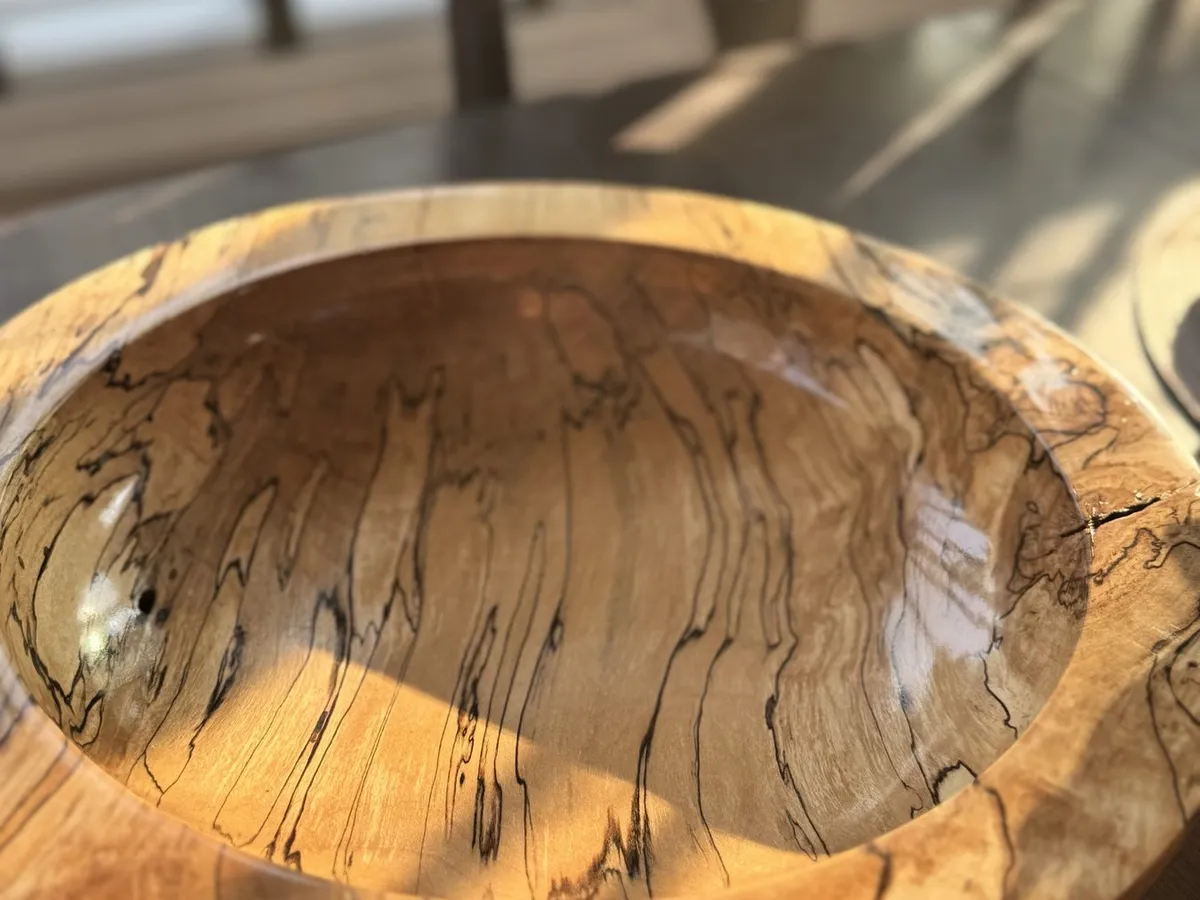 14-inch spalted maple bowl illuminated by warm indoor sunlight on a dining table