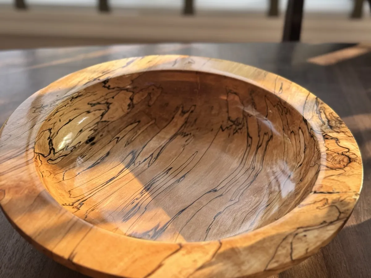 Angled view of 14-inch spalted maple bowl showing wide flat rim and smooth interior basin